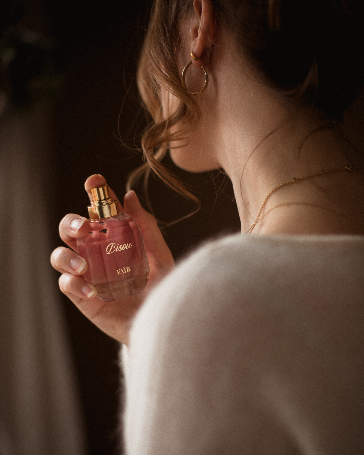 women applying Bisou by Faîr Parfum